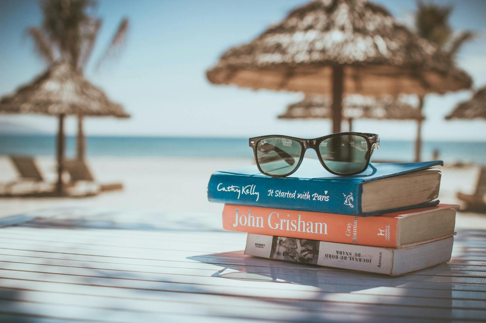 Books on a beach with sunglasses